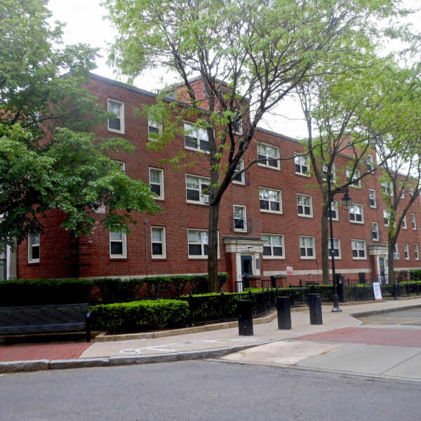 brick apartment building with trees in front