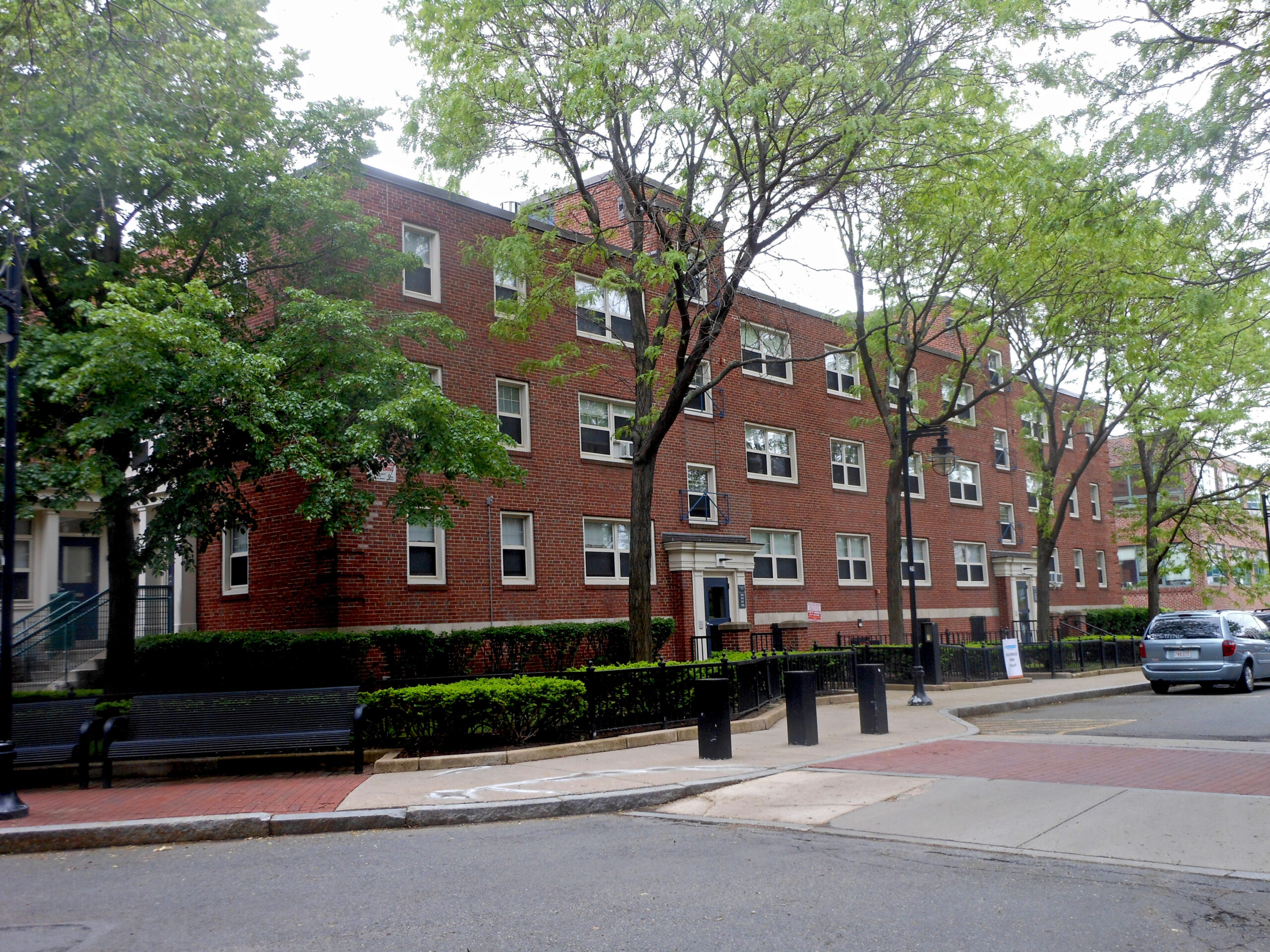 brick apartment building with trees in front