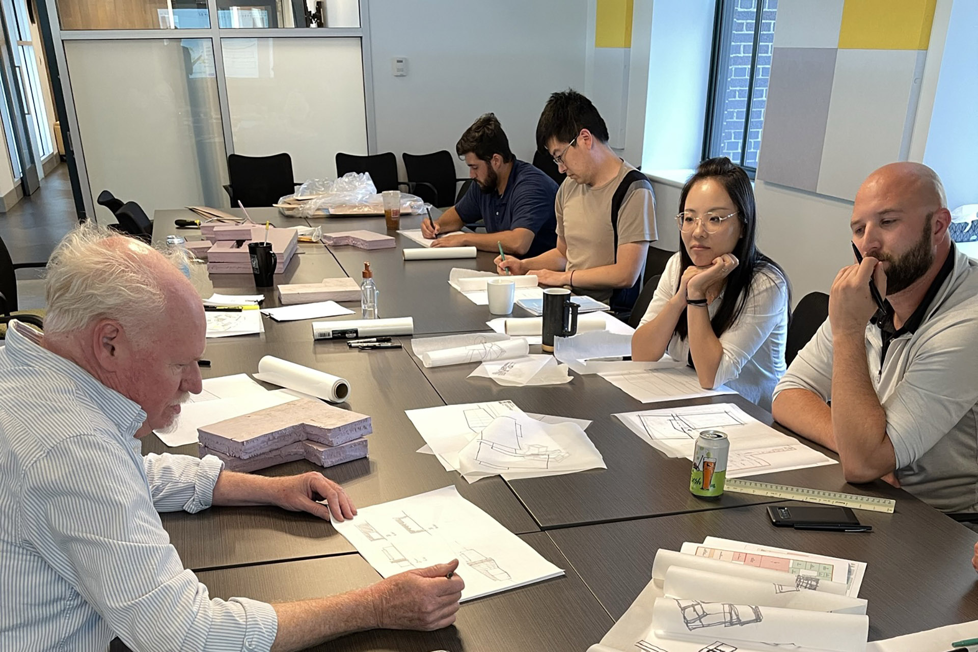 Dietz employees at conference table with architectural sketches